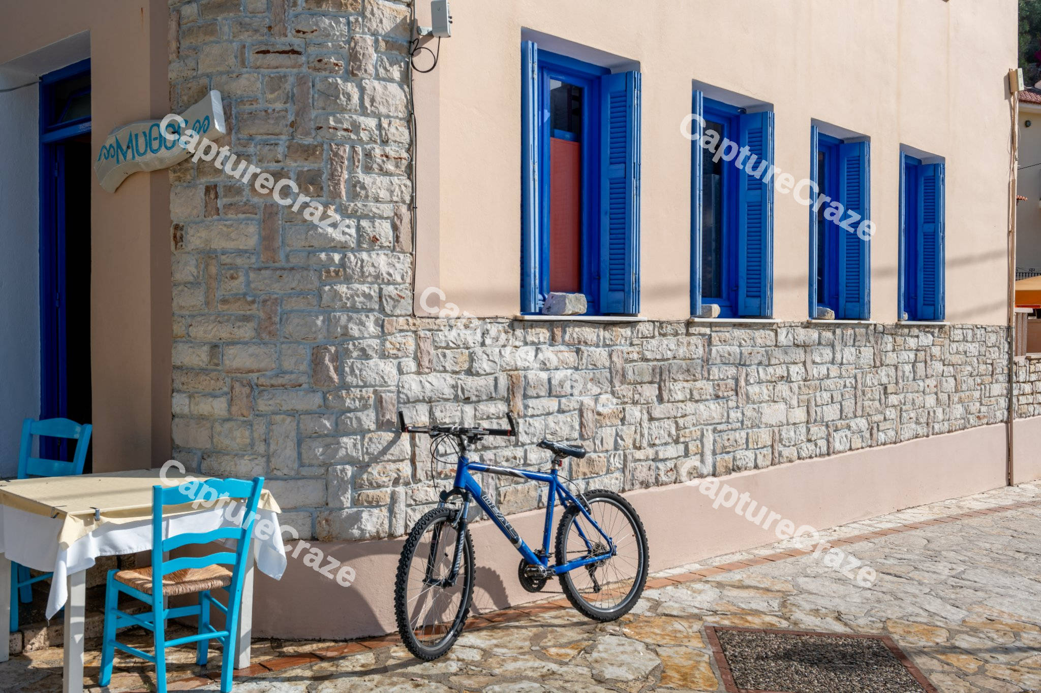 Blue bicycle in front of a stone house